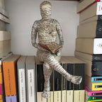 Lesende Figur aus Kunstharz mit Zeitungsdruck-Optik Zorenza