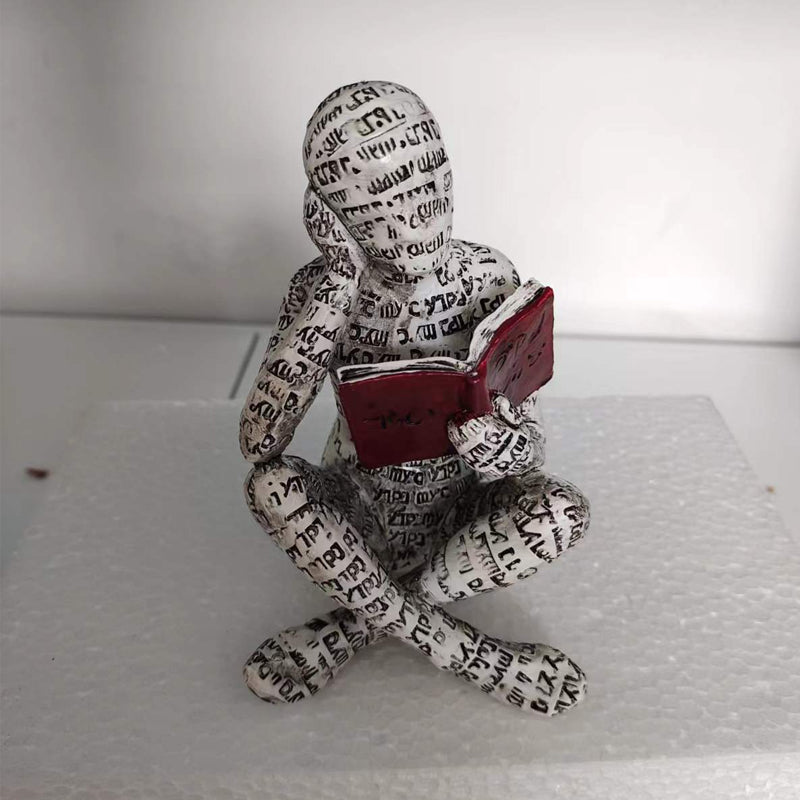 Lesende Figur aus Kunstharz mit Zeitungsdruck-Optik Zorenza